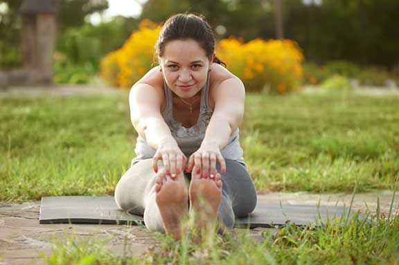 Eine Frau beim Yoga-Kurs auf einer Wiese